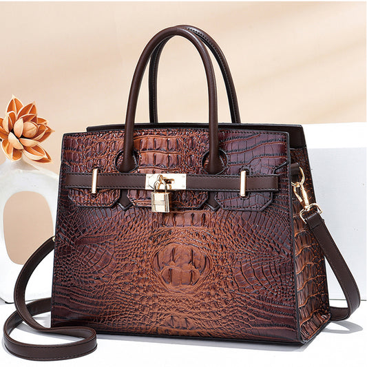 Medium size women hand bag with lock in brown for office use.